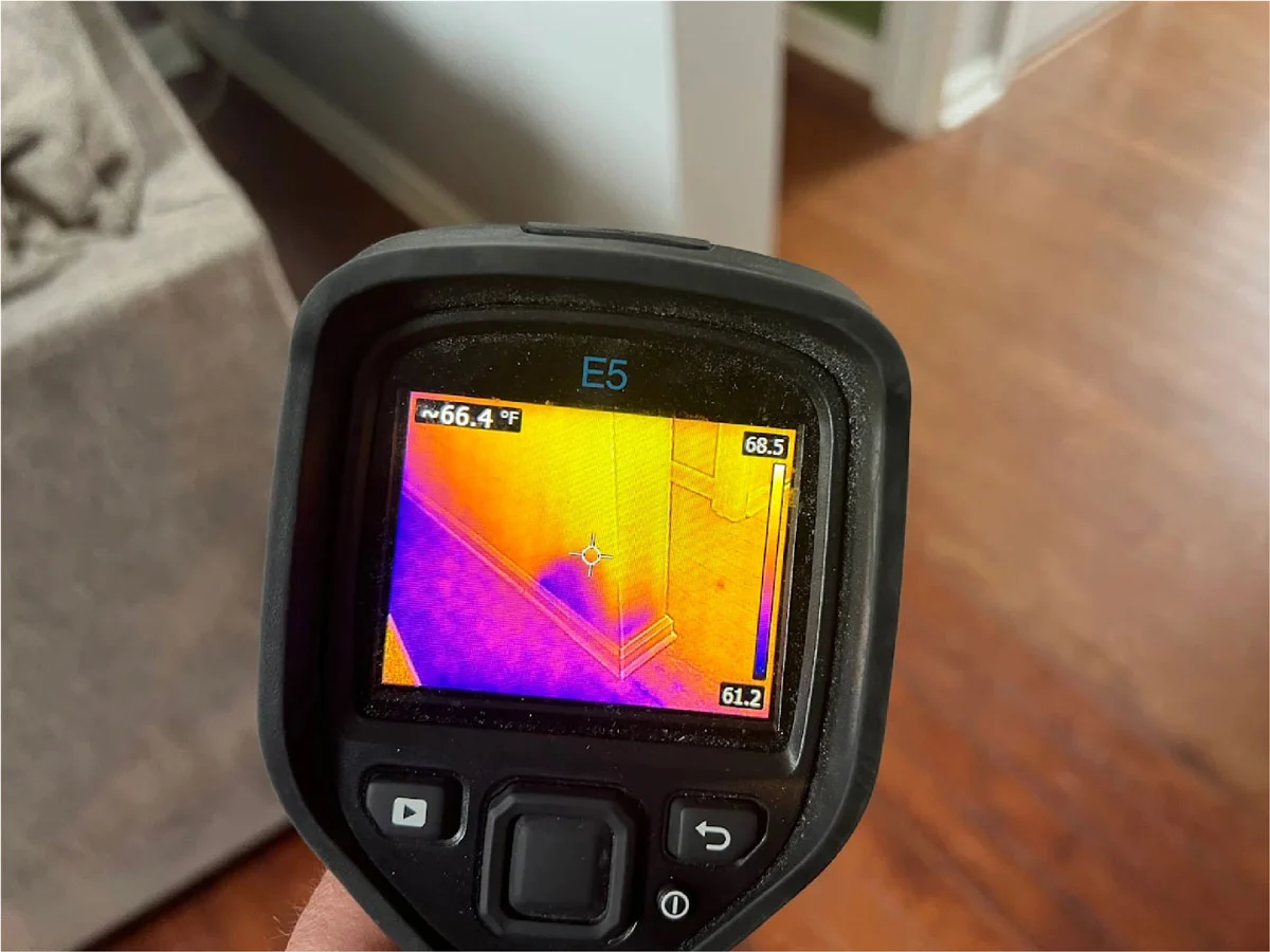 technician using thermal imaging camera on wall